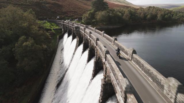 Una motocicletta che passa sopra una diga nel Galles